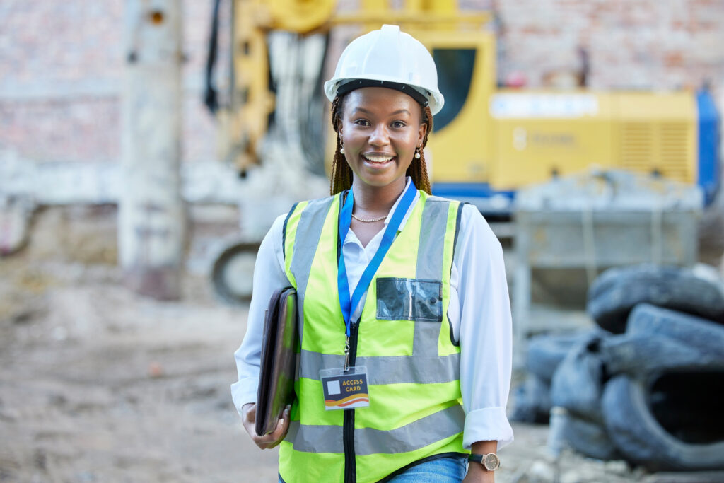 happy engineer, construction worker or architect woman feeling proud and satisfied with career opportunity. portrait of black building management employee or manager working on a project site