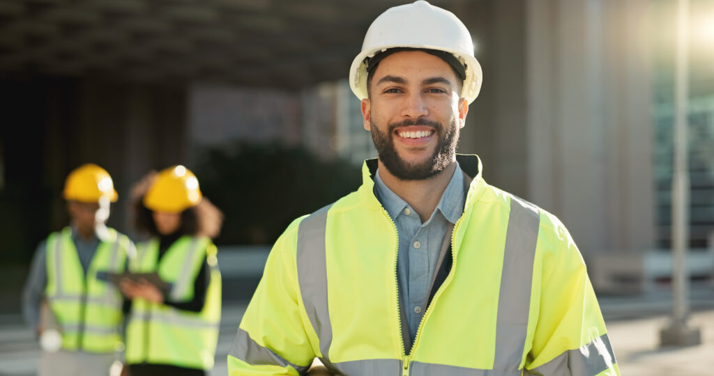 smiling construction professional wearing hard hat and vest