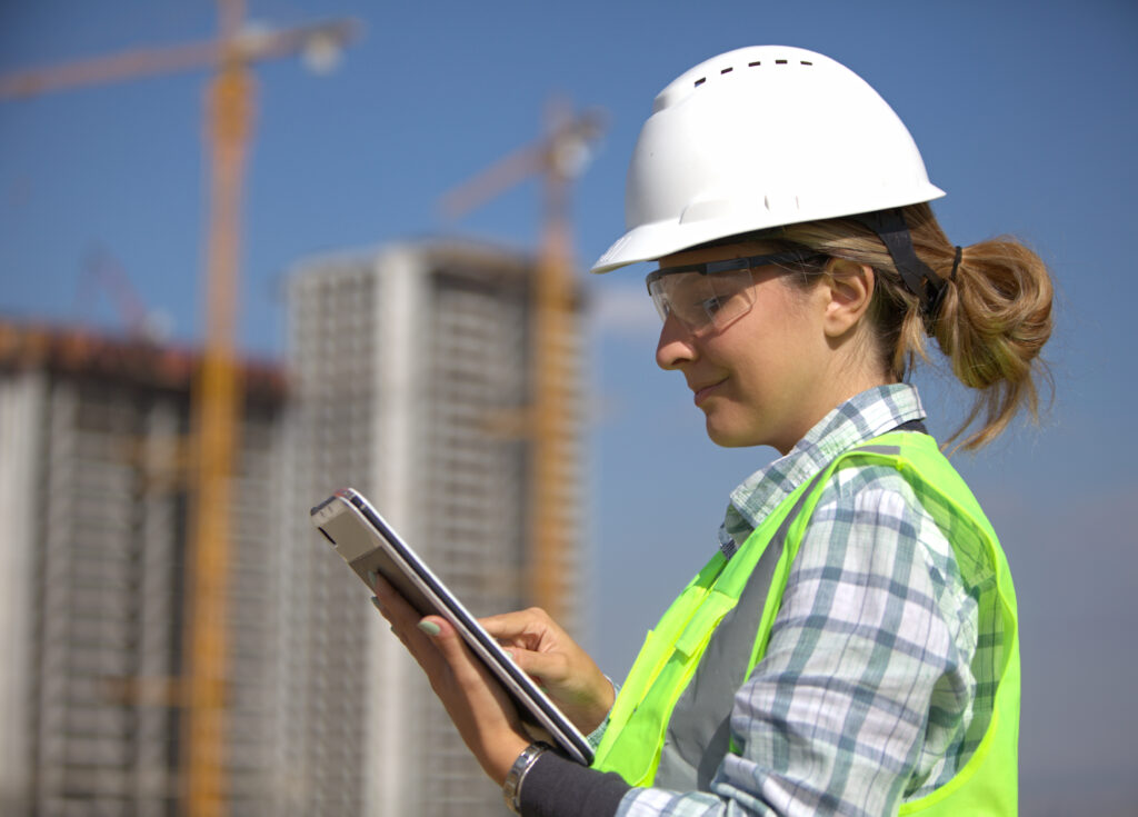 female civil engineer checking her plans using a tablet at the construction site.